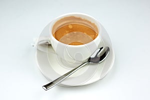 Coffee on a white plate with a spoon on a white background