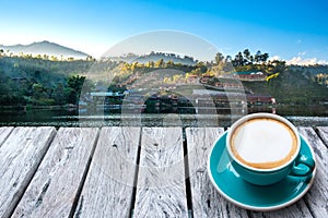 Coffee on wood table and view of landmark of Rak Thai Village in Mae Hong Son,T