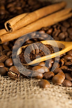 Coffee on wooden spoon on a burlap textured background
