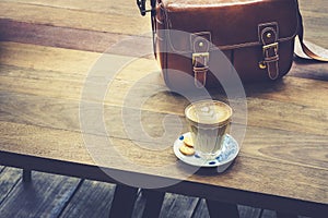 Coffee on wooden table with leather Bag Hipster lifestyle outdoor