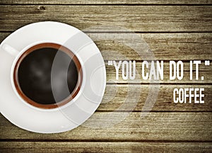 Coffee on wooden table with motivation quote