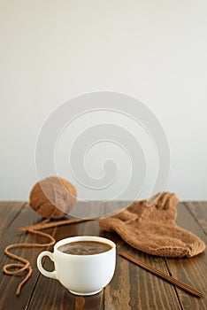 Coffee, woolen sock and knitting on a table