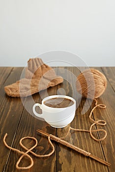 Coffee, woolen sock and knitting on a table