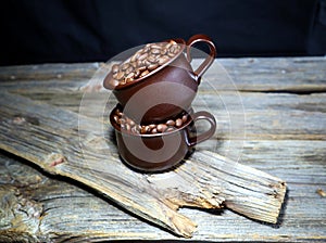 Coffeebeans in some ceramic coffee cups on a wooden table