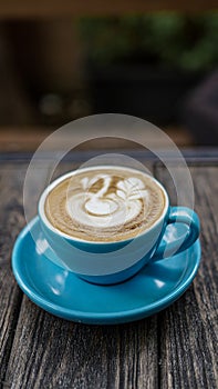 coffeelatte with blue cup and goose draw in topping