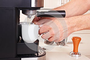 Coffeemaker hands makes two cups of espresso in coffee machine