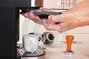 Coffeemaker inserts holder into coffee machine to make espresso