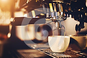 Coffeemaker pouring coffee into a cup.