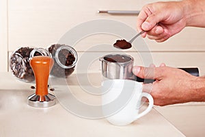 Coffeemaker pours ground coffee into the holder of coffee machine