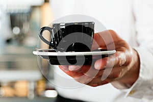 Coffeeshop - barista presents coffee or cappuccino photo