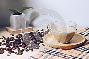 Coffeeâ€‹ cupâ€‹ andâ€‹ seedâ€‹ coffeeâ€‹ onâ€‹ woodenâ€‹ tableâ€‹