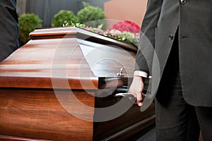 Coffin bearer carrying casket at funeral photo