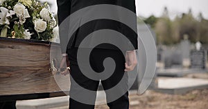 Coffin, hands and man walking at funeral ceremony outdoor with pallbearers at tomb. Death, grief and person carrying