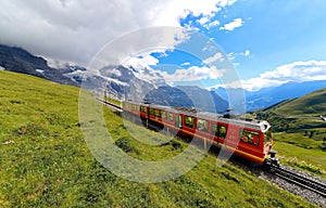 A cog-wheel train travels on famous Jungfrau Railway from Kleine Scheidegg to Jungfraujoch station ( top of Europe )