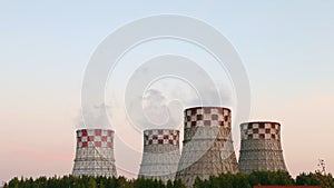 Cogeneration power plant in city. Tilting down from blue sky to pipes tubes chimney-stalk. Thermal Power Station chimney