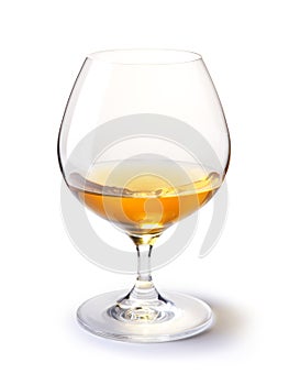 Cognac glass with gold cognac on a white