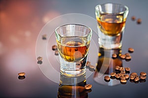 Cognac or liqueur, coffee beans and spices on a glass table.