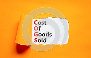 COGS cost of goods sold symbol. Concept words COGS cost of goods sold on white paper on beautiful orange background. Business COGS