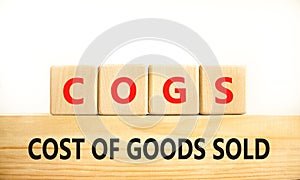 COGS cost of goods sold symbol. Concept words COGS cost of goods sold on wooden block on beautiful white background. Business COGS