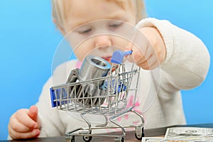 A cogwheel lies in a shopping cart and a child carries it on dollar bills. The concept of advertising cleanliness and decency in