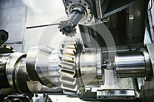 Cogwheel on shaft milling process. Industrial CNC metal machining by vertical mill