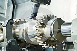Cogwheel on shaft milling process. Industrial CNC metal machining by vertical mill