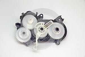 Cogwheels mechanism in black plastic case. Part of inkjet printer: complex mechanical drive made of Multiple reducer gears of