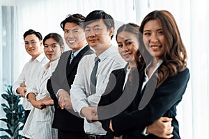 Cohesive office workers holding hand in line to promote harmony in workplace.