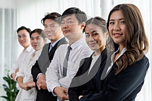 Cohesive office workers holding hand in line to promote harmony in workplace.