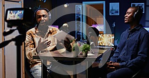 Cohosts streaming podcast using professional vlogging gadgets