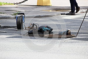 a coil of cable on the coil, a puncher, an open hatch, working gloves. reportage photography