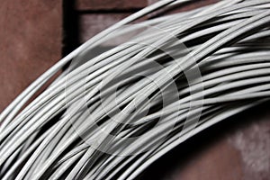 A coil of fechral thick refractory wire hangs in a warehouse of goods for ceramists. Frame of coiled nichrome wire for photo