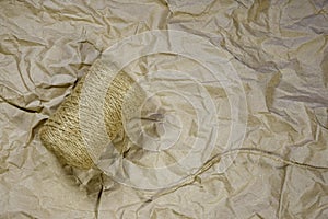 Coil of Hemp Twine on crumpled wrapping paper. Top view. Background, texture. Copy space