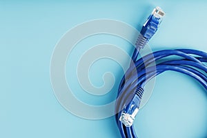 A coil of an Internet network cable for data transmission on a blue background