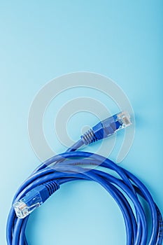 A coil of an Internet network cable for data transmission on a blue background