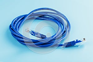 A coil of an Internet network cable for data transmission on a blue background