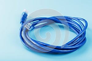 A coil of an Internet network cable for data transmission on a blue background