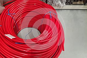 Coil of new shiny vivid red water thermo hosepipe in plastic