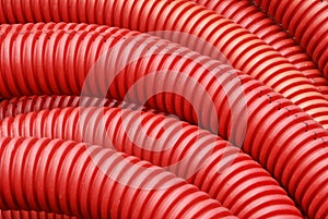 Coil of red plastic corrugated plumbing pipe