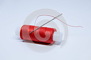 The coil of red thread . Needle with red thread