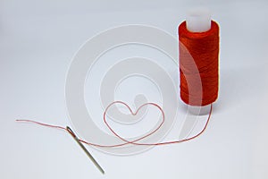 The coil of red thread . Needle with red thread