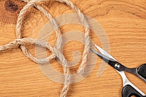 Coil of Rough Rope and Scissors on Wooden Background, Top View