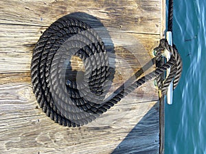 Coiled black rope on dock