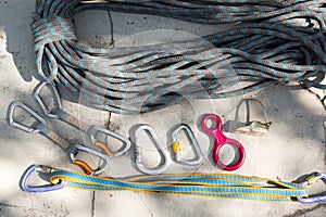 Coiled climbing rope and steel carabiner. Mountain climbing equipment: harness, brakes, quickdraws, self-insurance, belay device e