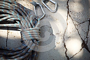 Coiled climbing rope and steel carabiner. Mountain climbing equipment: harness, brakes, quickdraws, self-insurance, belay device e