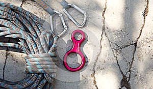 Coiled climbing rope and steel carabiner. Mountain climbing equipment: harness, brakes, quickdraws, self-insurance, belay device e