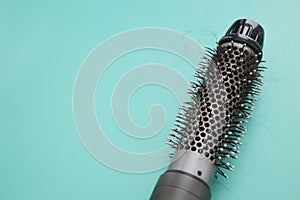 Coiled hair on an electric hair dryer after drying. Hair loss. Hairdryer with round brush. Rotating hair brush, styler, barber