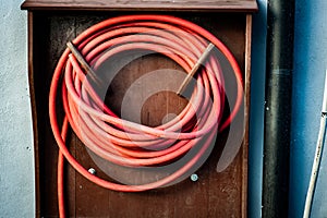 Coiled hose in wooden casing