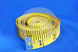 A coiled-like measuring tape isolated on blue