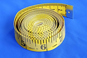 A coiled-like measuring tape isolated on blue